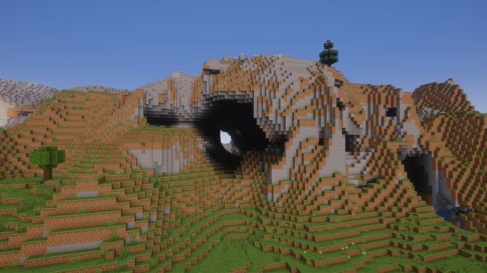 Um bioma de colinas extremas no servidor Minecraft com uma caverna atravessando a colina.